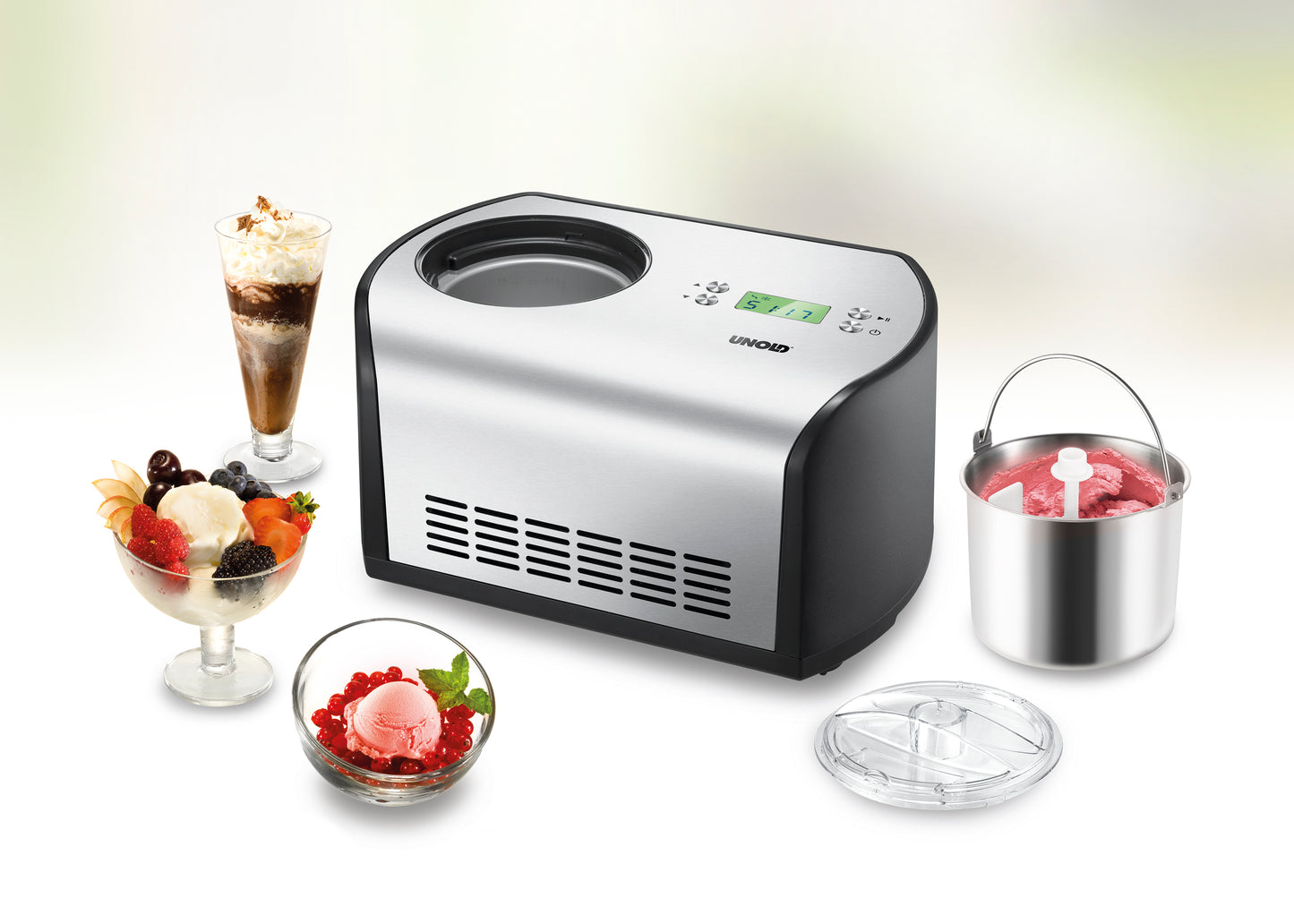 Die Unold Eismaschine One inklusive Eisbuch 1,2 L in Silber und Schwarz präsentiert sich auf einer weißen Fläche mit digitalem Display, umgeben von Eisdesserts, einer Mixschüssel mit rosa Eis und einem transparenten Deckel.