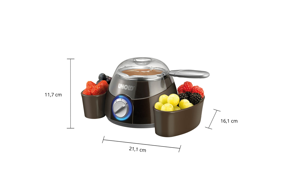 Der Schokoladenfondue-Maker von Unold Chocolatier verfügt über ein silbernes Oberteil, ein blaues Zifferblatt und zwei braune Obstschalen an beiden Seiten. Seine Abmessungen betragen 21,1 cm Breite, 11,7 cm Höhe und 16,1 cm Tiefe.