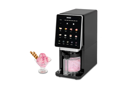Die Unold AG Eismaschine Cream Dream ist eine schwarze Tisch-Eismaschine mit digitalem Touchscreen und einem durchsichtigen Behälter mit rosa Eis, der neben einer Glasschale mit rosa Kugeln und Waffelstäbchen zu sehen ist.