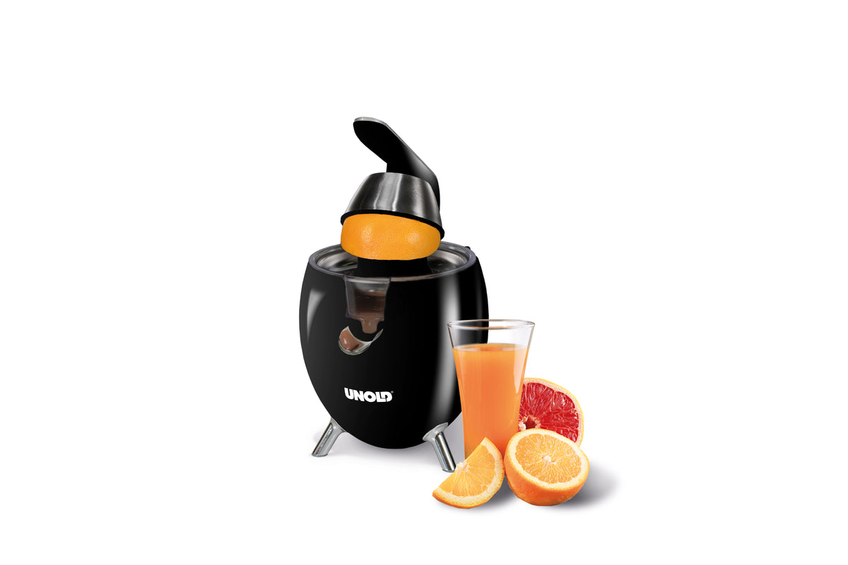 Eine schwarze elektrische Zitruspresse mit einer Orange darauf, einem Glas Orangensaft und Orangen- und Grapefruitscheiben vor der Presse auf weißem Hintergrund.