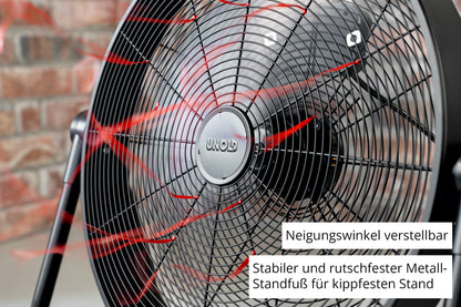 Nahaufnahme des Unold Windmaschine Black Steel Standventilators mit roten Luftstromlinien, verstellbarer Neigung und einem stabilen, rutschfesten Metallsockel. Vor dem Hintergrund einer Backsteinmauer.