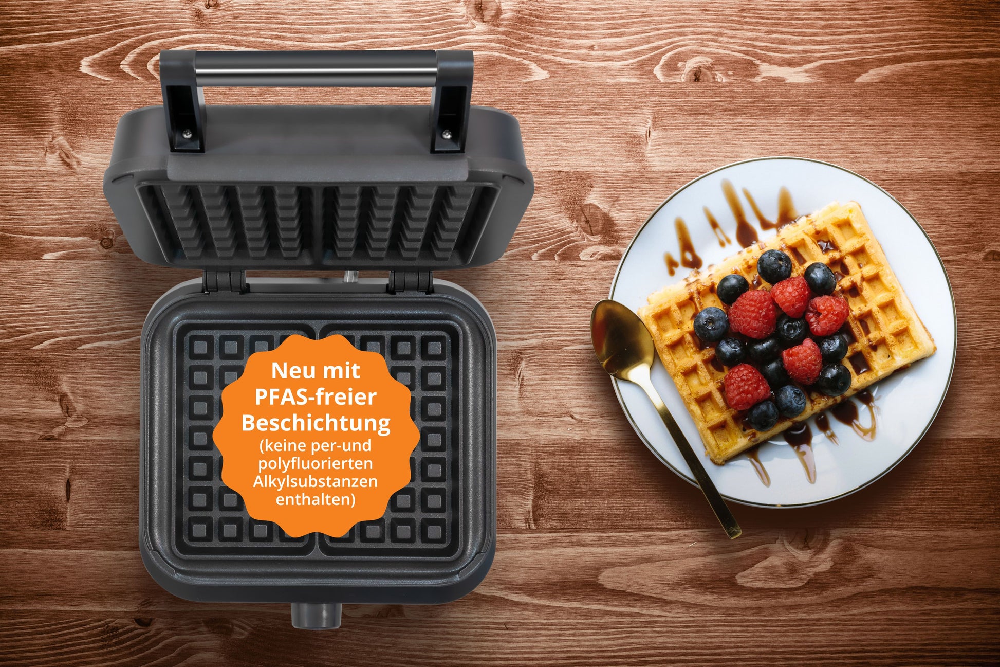 Der Unold BELGISCHES WAFFELEISEN Brüssel mit der Aufschrift "Neu mit PFAS-freier Beschichtung" ist neben einem Teller mit einer Waffel mit Beeren und einem Löffel auf einer Holzfläche abgebildet.