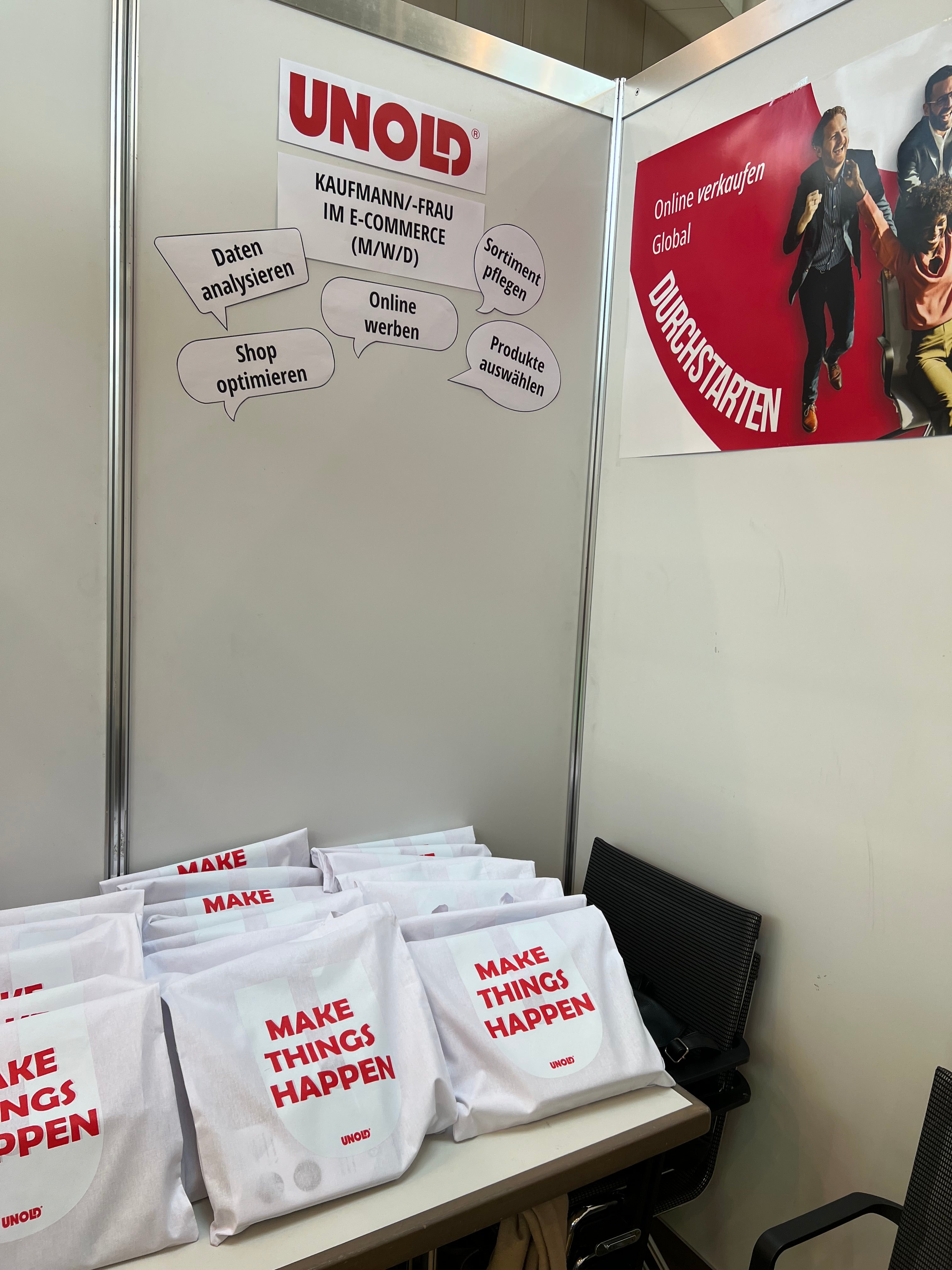 Auf dem Stand sind UNOLD-Markenzeichen, Werbetaschen mit der Aufschrift „MAKE THINGS HAPPEN“ und eine Wand mit Karriereinformationen zu Rollen im E-Commerce, darunter Aufgaben wie Datenanalyse und Online-Werbung, zu sehen.