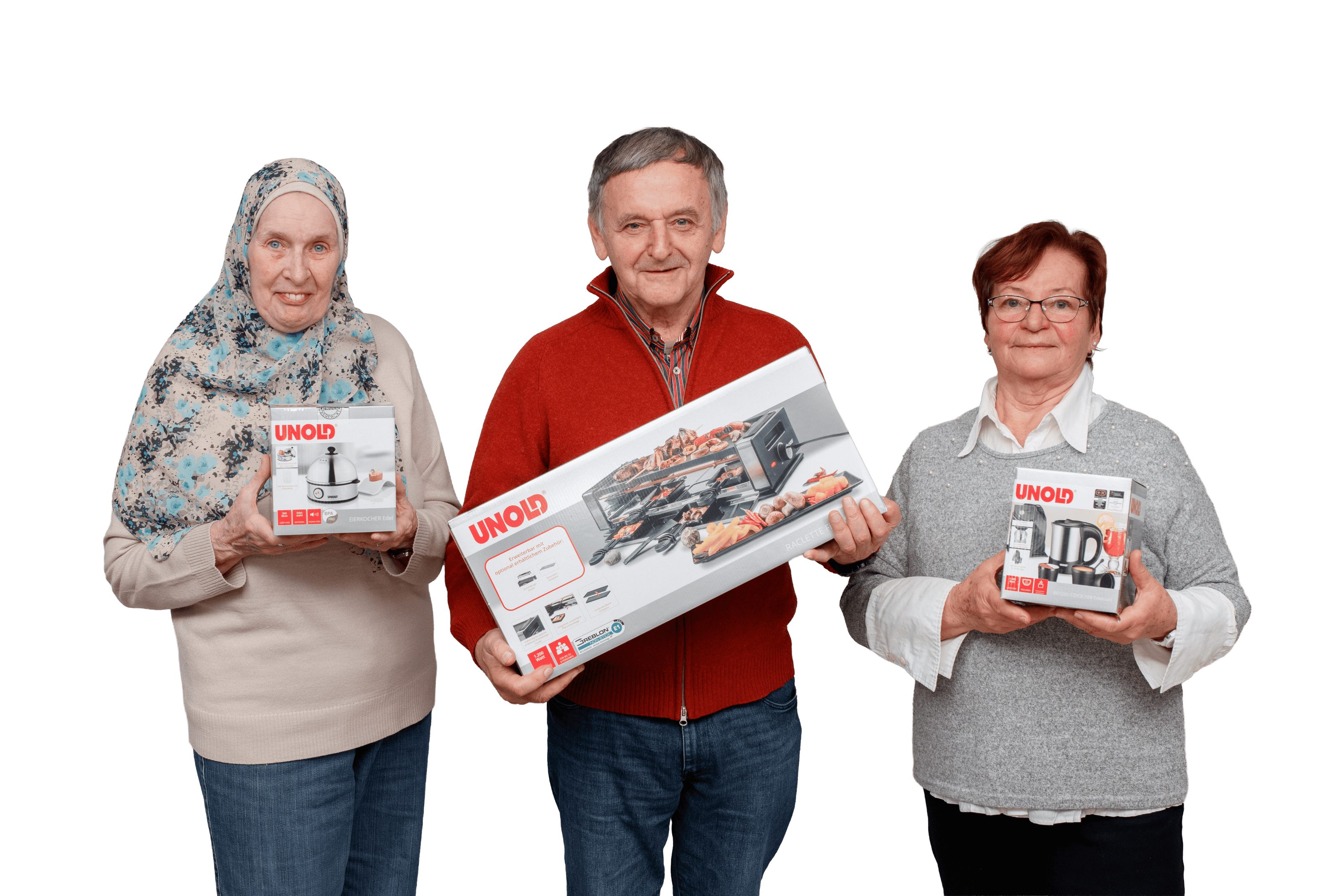 Drei ältere Erwachsene stehen lächelnd da und halten jeweils ein verpacktes UNOLD-Küchengerät vor einem schlichten weißen Hintergrund. Die Frau auf der linken Seite trägt einen Hidschab, der Mann in der Mitte einen roten Pullover mit Reißverschluss und die Frau auf der rechten Seite trägt eine Brille.