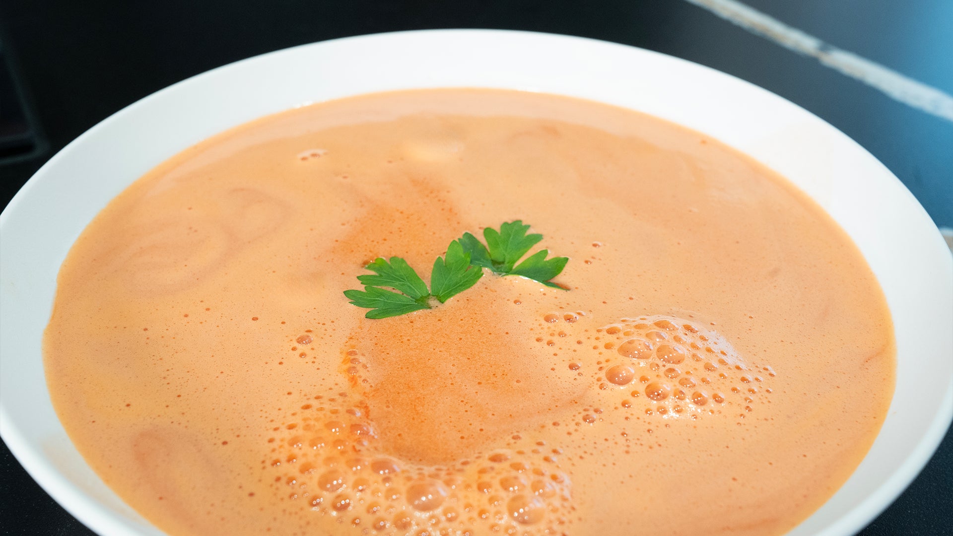 Tomatensuppe mit Petersilie in einem weißen Teller